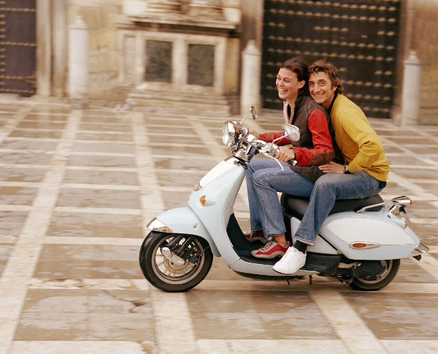 Vrouw en man op scooter in Italie